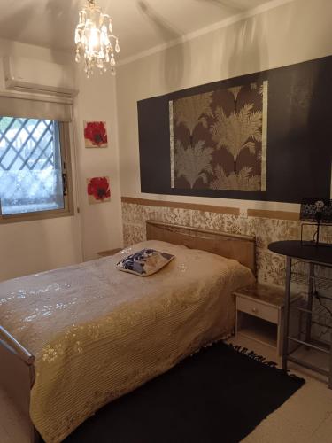 una camera da letto con un letto e un lampadario di Golden sunshine a Paralimni