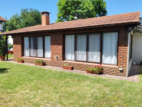 ein kleines Backsteinhaus mit Fenstern auf einem Hof in der Unterkunft Quincho in Mar del Plata