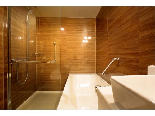 a bathroom with a tub and a sink and a shower at Hotel Trusty Nagoya Shirakawa in Nagoya