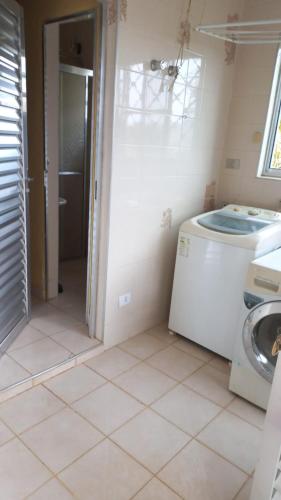 a laundry room with a washer and a washing machine at Chácara do Sossego in Piracaia