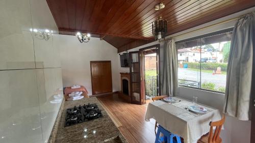 eine Küche mit Tisch und Herd oberen Backofen in der Unterkunft Chalés Ipe Amarelo in Camanducaia