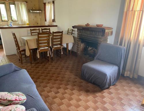 a living room with a fireplace and a table and chairs at Duplex la 70 in San Clemente del Tuyú