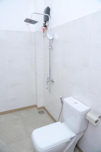 a white bathroom with a toilet and a shower at Moon Town in Aluthgama