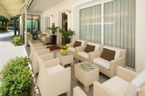 eine Terrasse mit Sofas, Stühlen und einem Tisch in der Unterkunft Hotel Ferrara in Cattolica