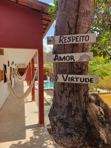 a tree with street signs attached to a tree at Maruá Pousada da Lagoa in Jijoca de Jericoacoara