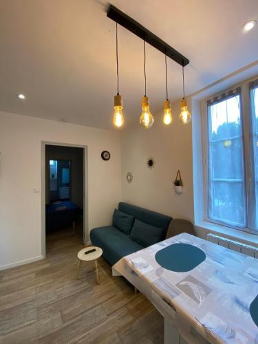 ein Wohnzimmer mit Sofa und Tisch in der Unterkunft Appartement calme à Saint Maixent l'Ecole in Saint-Maixent-lʼÉcole