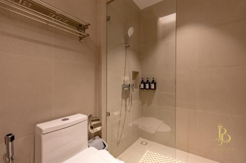 Un baño con inodoro y ducha de cristal. en The Bentley Hotel, en Bangkok
