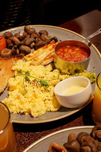 Un plato de comida con huevos y frijoles en una mesa. en Miller & Carter Heaton Chapel by Innkeeper's Collection, en Mánchester
