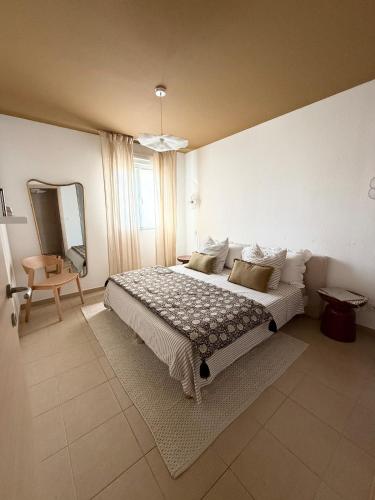 a bedroom with a large bed and a mirror at Beautiful 2 bedroom apartment with pool in Saint Florent in Oletta