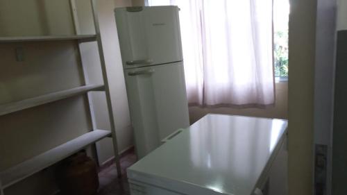 una nevera blanca en una cocina con ventana en Chácara do Sossego, en Piracaia