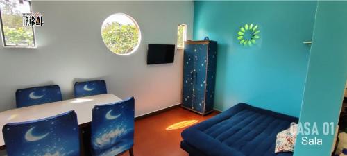 Zimmer mit einem Tisch, Stühlen und einem Sofa in der Unterkunft Chalé tribal Vermelho in Alto Paraíso de Goiás