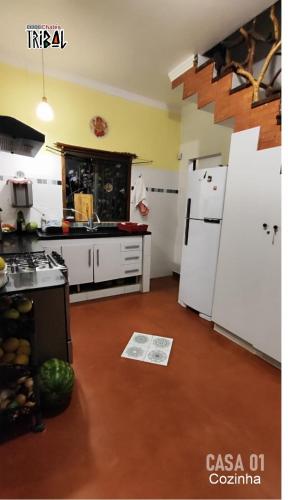 a kitchen with white appliances and a counter top at Chalé tribal Vermelho in Alto Paraíso de Goiás