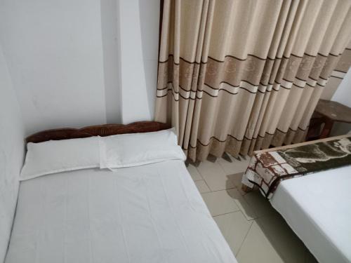 1 Schlafzimmer mit 2 Betten und einem Vorhang in der Unterkunft Diyatalawa Mountain Holiday Resorts in Diyatalawa