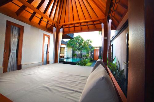 a bedroom with a large bed in a house at The Banyumas Suite Villa Legian in Legian