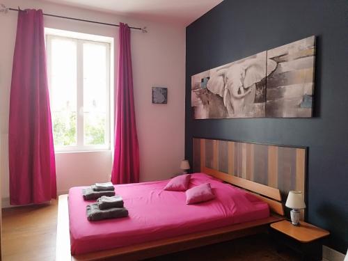 - une chambre avec un grand lit rose et des draps roses dans l'établissement Villa 1893, à Le Pavé