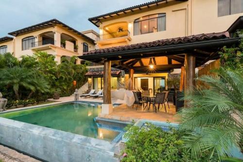 普拉卡海尔Casa Serena Luxury Retreat in Reserva Conchal的一栋房子前面有游泳池