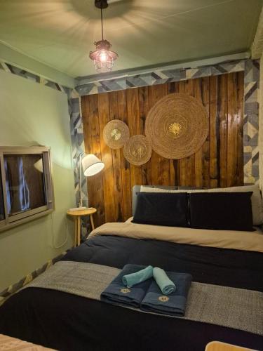 a bedroom with a bed with a wooden wall at Baan Koody Hostel in Ko Kut