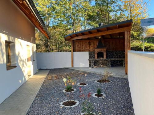 einen Hinterhof mit einer Steinterrasse mit einem Pavillon in der Unterkunft Holiday Home Počúvadlo in Počúvadlo