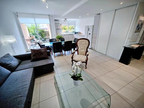 ein Wohnzimmer mit einer Couch und einem Glastisch in der Unterkunft Terrasse de Malissol in Vienne