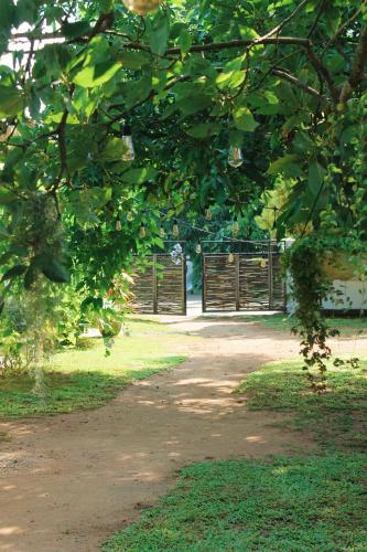 a dirt road with a wooden gate in a park at Solmate Collective Guesthouse - Madiha in Matara