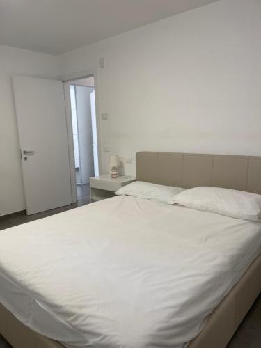 a large white bed in a room with a door at Villa Malù in Lignano Sabbiadoro