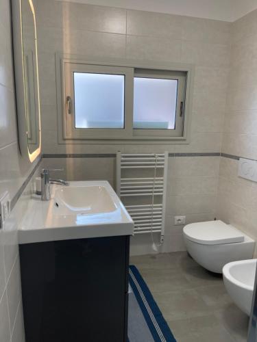 a bathroom with a sink and a toilet at Villa Malù in Lignano Sabbiadoro