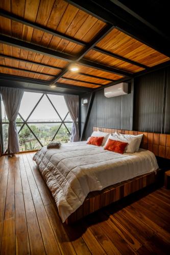 a bedroom with a large bed with a large window at Hotel Coyote in San Miguel de Allende