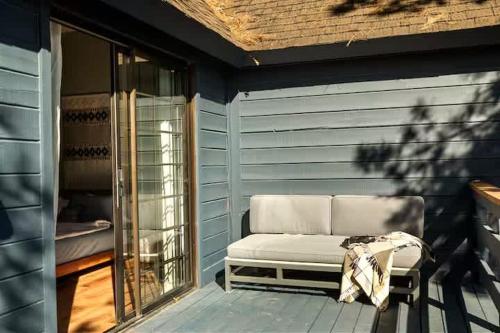 eine Bank, die auf einer Veranda neben einer Tür sitzt in der Unterkunft Lumiere Cabin in Blue Jay