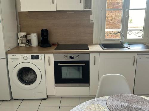 a kitchen with a washing machine and a sink at L'observatoire in Le Havre