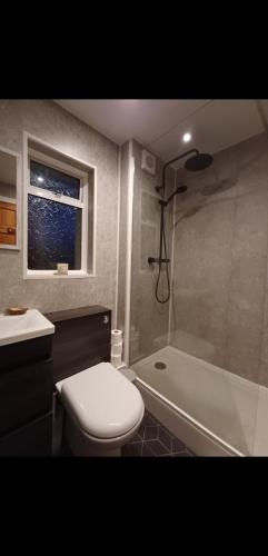 une salle de bain avec toilettes, baignoire et lavabo dans l'établissement Home in Thurso NC500, à Thurso