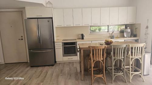 a kitchen with a refrigerator and a table with chairs at הבית בשביל הזהב in Caesarea