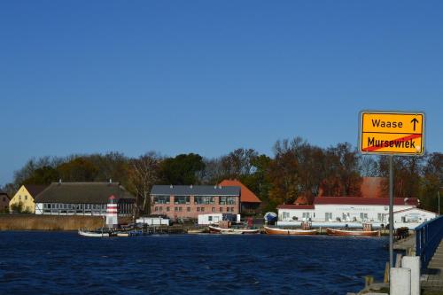 a sign on a dock with boats in the water at Komfortable Ferienwohnung In Waase Mit Garten in Ummanz