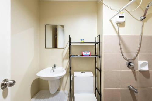 Un baño con lavabo, inodoro y ducha. en Studiotel CDO City Netflix WiFi Pool Access, en Cagayan de Oro