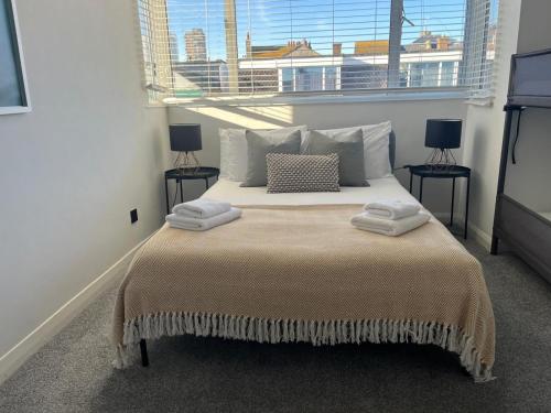 a bedroom with a large bed with two windows at The Lanes Townhouse Retreat in Brighton & Hove