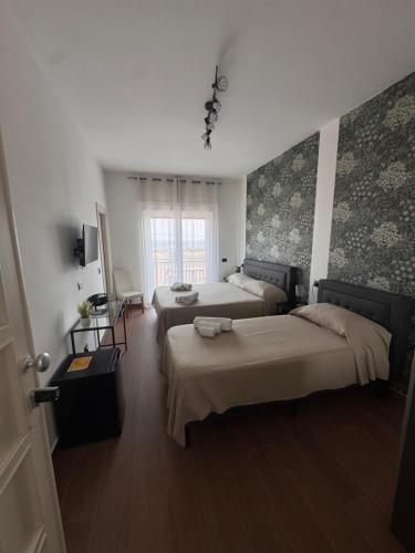 a bedroom with two beds and a window at Casa Angelina in Mirto