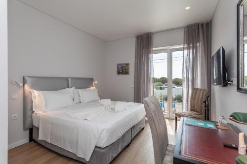 a hotel room with a bed and a balcony at BeGuest Estoril Guesthouse in Estoril