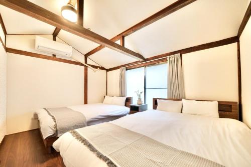a bedroom with two beds and a window at Sen Yokohama 2K house near Bandobashi Sta 横浜阪東橋 in Yokohama