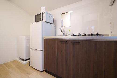 a kitchen with a white refrigerator and a sink at Sen Yokohama 2K house near Bandobashi Sta 横浜阪東橋 in Yokohama