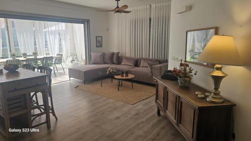 a living room with a couch and a table at הבית בשביל הזהב in Caesarea