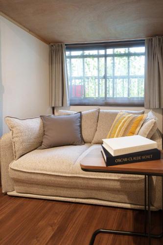 a couch with two books on a table in a room at Sen Yokohama 2K house near Bandobashi Sta 横浜阪東橋 in Yokohama