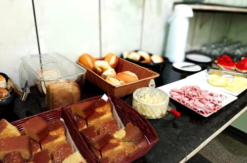 un tavolo con pane e cesti di cibo sopra di Hotel Coutinho PIO XII a Pirapora