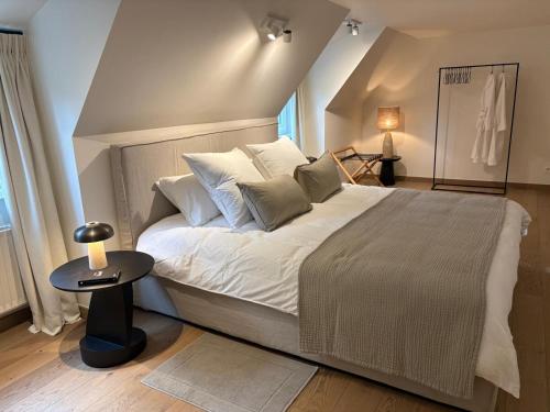 ブランケンベルヘにあるMaison 42の大きなベッドとテーブルのある寝室