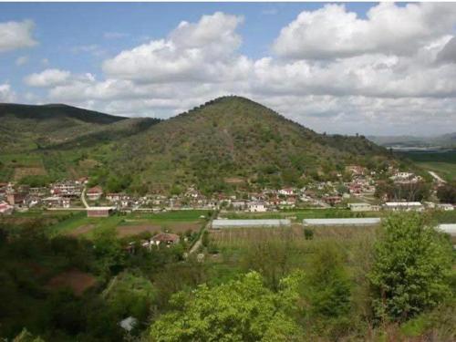 una pequeña ciudad en una colina con una montaña en Syzes, en Polisi i Vogël
