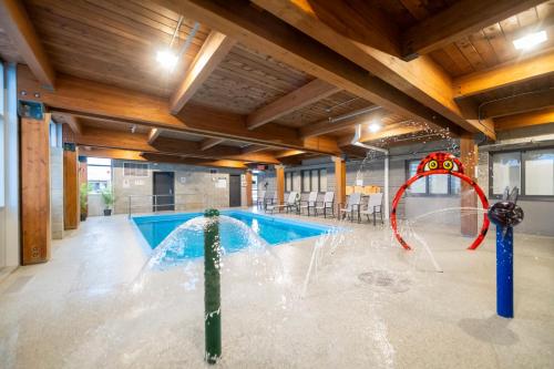 a pool with a water slide in a building at Hôtel & Suites Le Dauphin Québec in Quebec City