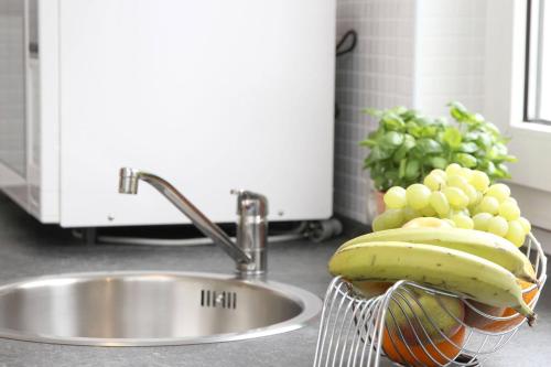 Ein Korb mit Bananen und Weintrauben neben dem Waschbecken in der Unterkunft Sophias Ferienwohnung Brilon in Brilon