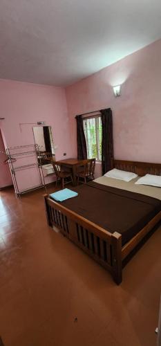 a large room with two beds and a table at Lakeview Meadows in Vagamon