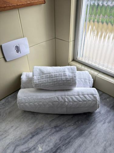 a couch sitting in a room with a window at GoldMen Business Hotel Blumenau in Blumenau