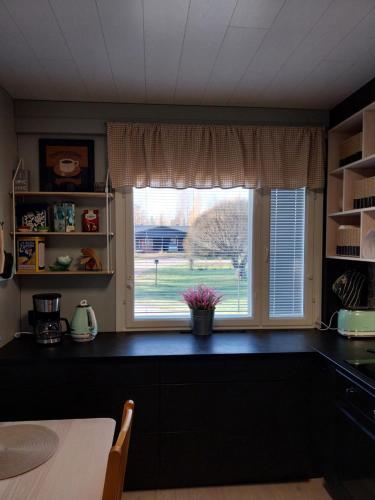 een keuken met een groot raam en een tafel bij Järvenranta in Jämsä