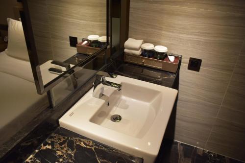 a bathroom with a white sink and a mirror at Ramada Foshan Hotel in Foshan