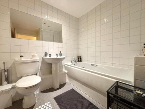 a bathroom with a toilet and a tub and a sink at Central Station Apartment in Central Station